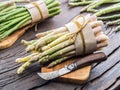 Green and white types of asparagus sprouts on wooden table. Top