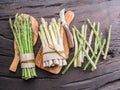 Green and white types of asparagus sprouts on wooden table. Top