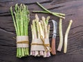 Green and white types of asparagus sprouts on wooden table. Top view