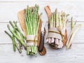 Green and white types of asparagus sprouts on wooden table. Top view