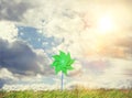 Green windmill toy on grass on summer day