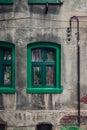 A green window with a green window sill against the background of a gray, plastered, damaged wall Royalty Free Stock Photo