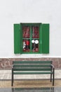 Green window with red pepper on a white wall.