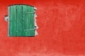 Green window on red stucco wall. Vivid bright red colour house home facade with green wooden window Royalty Free Stock Photo