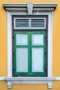 Green window on a yellow wall