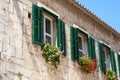 Green windows on the facade old stones house. Royalty Free Stock Photo