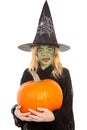 Green witch for halloween holding pumpkin