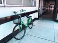 Green woman a bike againtst the white wall