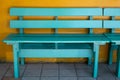 Green wood bench with yellow cement wall Royalty Free Stock Photo