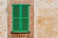 Green wood window shutter with rustic plaster wall Royalty Free Stock Photo