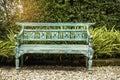 Green wooden bench in a city park in spring time and trees on background Royalty Free Stock Photo