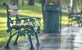 Green wooden bench in a summer park during the rain. Royalty Free Stock Photo