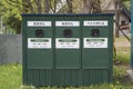 Green wooden bins in a zoo near a park for a recycling programme; empty can, empty bottle and plastic bottle. Royalty Free Stock Photo