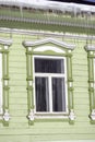 Green wooden countryhouse, facade and window. Icicles cover the roof. Royalty Free Stock Photo