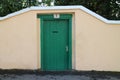 Green wooden dooor in wall in Uzhorod