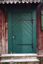 Green wooden door on the old wooden facade of the house Royalty Free Stock Photo