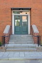 Green wooden door on the red brick wall