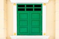 Green wooden door and white yellow cement wall Royalty Free Stock Photo