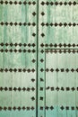 Green wooden door with wrought iron details