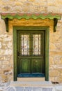 Green wooden door with wrought iron of a stone building Royalty Free Stock Photo