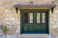 Green wooden door with wrought iron of a stone building Royalty Free Stock Photo