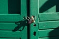 Green wooden doors locked with padlocks. Royalty Free Stock Photo