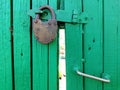 Green wooden fence with lock. Fence and gate cottages. Cottage in Russia.