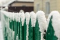 Green wooden fence under the snow, snowflakes fall, selective focus Royalty Free Stock Photo
