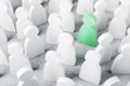 Green wooden figure as unique and talented person in business team stands in a crowd of white wooden figures as herd-minded people Royalty Free Stock Photo