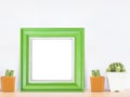 Green wooden frame with cactus in pot on wood table Royalty Free Stock Photo