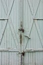 Green wooden gate of old warehouse, locked with padlock