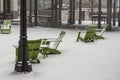 Green wooden lawn chairs covered in snow in urban Atlanta during winter