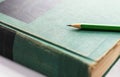 A green wooden pencil is placed on the hardback or textbook. selective focused Royalty Free Stock Photo