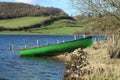 Green, wooden row boat at lake shore in rural Ireland Royalty Free Stock Photo