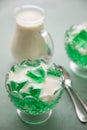 Green woodruff jelly and vanilla custard with spoons and glass bowls