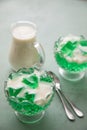 Green woodruff jelly and vanilla custard with spoons and glass bowls