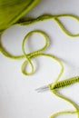 Green wool knitting work with needle & white background