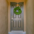 Green wreath on shiny gray front door of a home Royalty Free Stock Photo