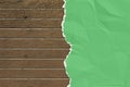 Green wrinkled paper ripped on the wooden board. Royalty Free Stock Photo