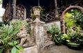 Green yard ancient estate in Thailand, with stone steps and traditional statues at the entrance