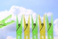 Green and yellow clothes pins sky Royalty Free Stock Photo