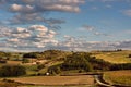 Green and yellow countryside under blue skies with white clouds Royalty Free Stock Photo