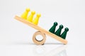 Green and yellow game pieces on a wooden seesaw