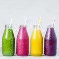 Green, yellow, pink and red smoothie in glass bottles Royalty Free Stock Photo