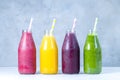 Green, yellow, pink and red smoothie in glass bottles Royalty Free Stock Photo