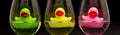 Green, yellow and pink rubber ducks in wineglasses