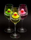 Green, yellow and pink rubber ducks in wineglasses