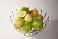 Green yellow red apples and a slice of lemons in a metal decorative basket Royalty Free Stock Photo