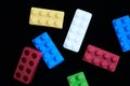 Colorful construction bricks with a paracetamol tablet on a black background