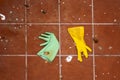 Green and yellow rubber kitchen gloves on the ground. Royalty Free Stock Photo